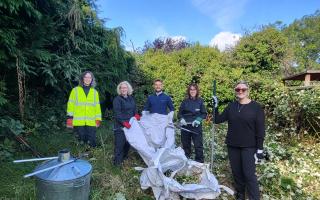 The UK Power Networks team at work clearing the overgrown garden.