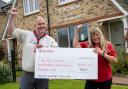 Brian Calvert from the 1st Ely Scouts accepts the cheque for £448 from Redrow sales assistant Sharon Stone