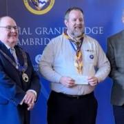 Phil Watson receives cheque from Ely Masons.