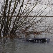 An Audi bobs in the water after becoming stuck in floods on Welney Wash Road