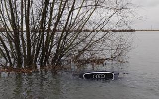 An Audi bobs in the water after becoming stuck in floods on Welney Wash Road